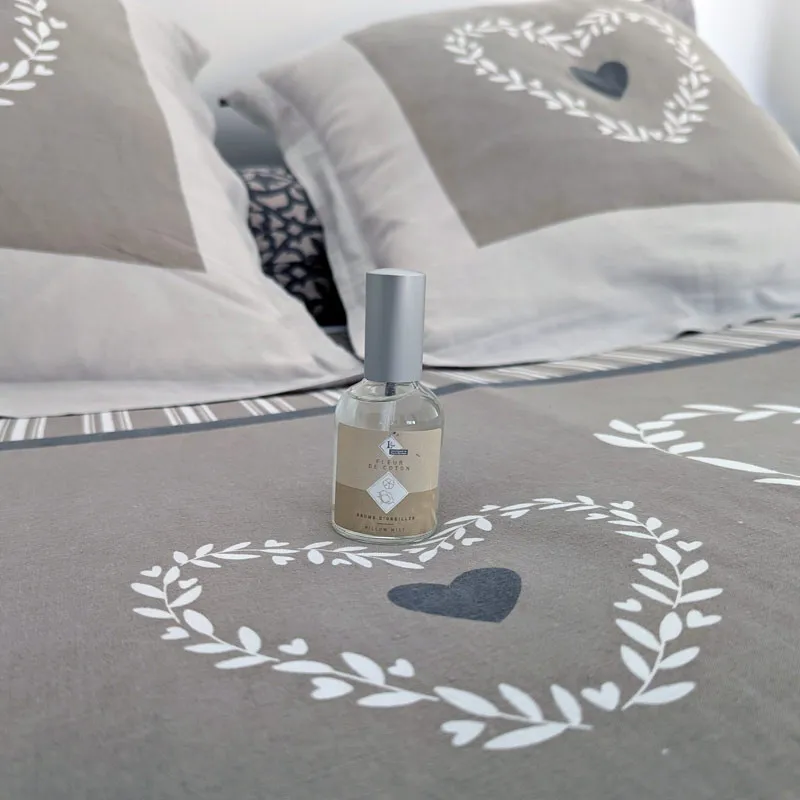 Brume d'oreiller fleur de coton posée sur un lit
