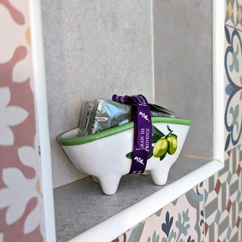 Porte-savon baignoire avec deux savons olive posés sur rebord de douche