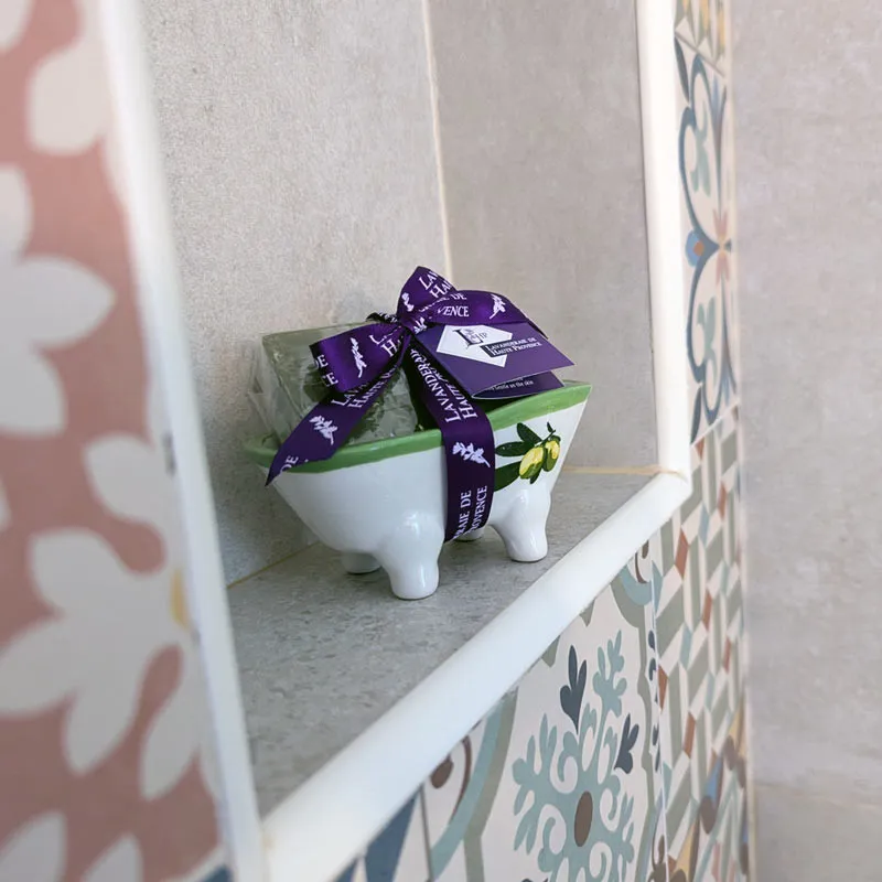 Mini porte-savon baignoire olive avec savon posé sur rebord de douche